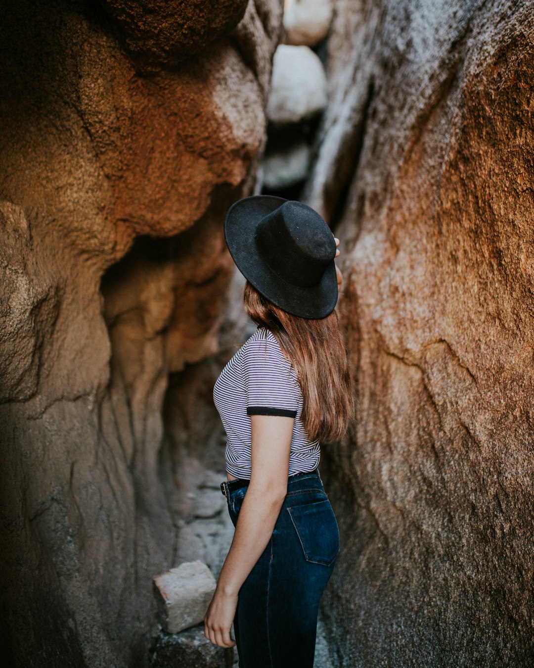 woman standing between narrow cave pathway