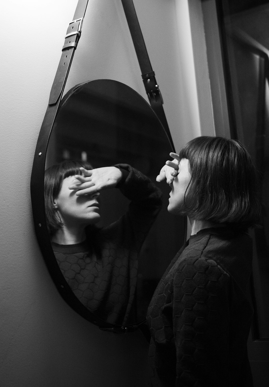 woman in black long sleeve shirt standing in front of mirror